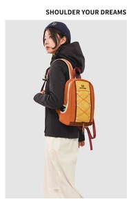 Detail view of large capacity orange and yellow drawstring backpack on female model