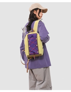 Rear view of outdoor contrast color backpack with purple panels and yellow accents on model