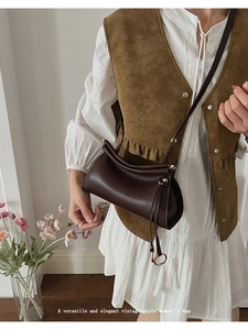 Détail d'un sac bandoulière vintage en cuir marron foncé avec fermeture incurvée unique
