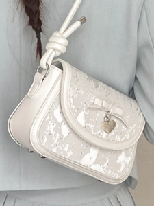 Sac bandoulière crème élégant avec imprimé papillon et pendentif coeur en vue de 45 degrés