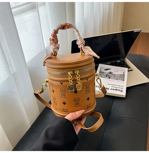 Détail du sac seau marron avec imprimé ours et poignée enroulée d'un foulard en soie