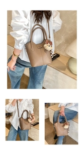 Detail of brown litchi pattern bucket bag with plush bear charm and stitch texture