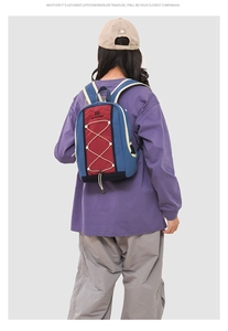 Detail of blue and red urban outdoor backpack with elastic drawstring and buckles