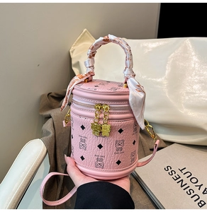 Détail du sac seau rose avec poignée en foulard de soie et zip tête d'ours doré