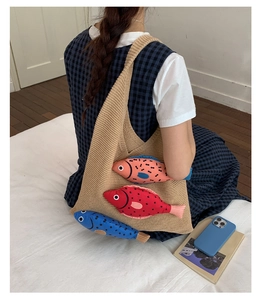 Detail of khaki knitted tote bag featuring three colorful 3D fish dolls with patterns