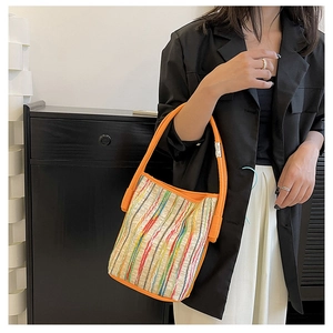 Detail der bunt gestreiften Canvas-Eimertasche mit orangefarbenem Leder-Schultergurt