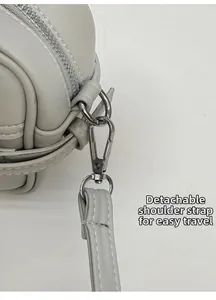Détail du sac en cuir beige clair avec bandoulière amovible et fermoir mousqueton argenté