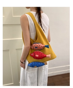 Detail of yellow knit shoulder bag featuring 3D colorful fish and textured stitch pattern