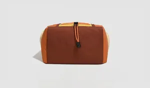 Detailed bottom view of water-resistant nylon backpack with orange elastic drawstring and buckles