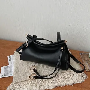Detailed close-up of light gold metal rings and spherical drawstring on a black PU bag