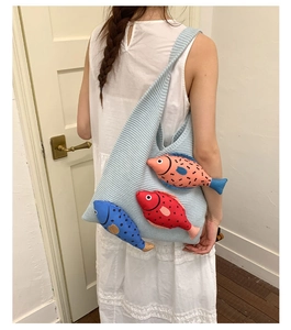 Detail of light blue knitted tote bag featuring three colorful 3D fish decorations