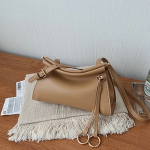 Detail of minimalist khaki leather shoulder bag with drawstring buckle and metal adjuster