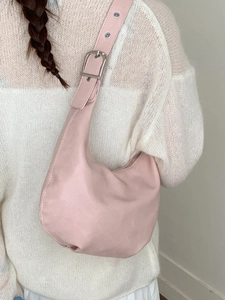 Pink PU leather hobo bag with adjustable strap worn on shoulder with white sweater