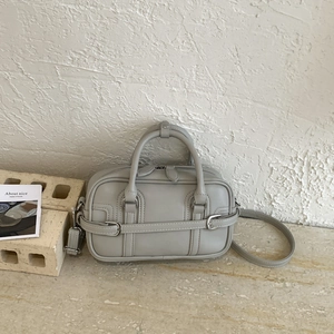 Détail du sac boston en cuir bleu clair avec poignées et bandoulière réglable amovible