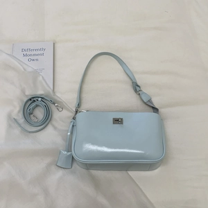 Close-up of light blue baguette bag with silver twist lock and smooth glossy finish