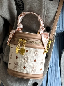 Sac seau cylindrique beige avec motif ours et poignée en foulard sur modèle