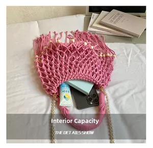 Dettaglio della capacità interna della borsa rosa intrecciata con nappe e perle