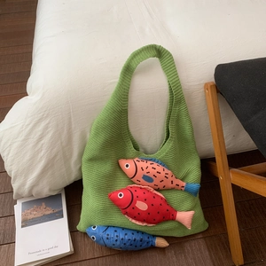 Gros plan d'un sac cabas vert tricoté avec des décorations de poissons en peluche