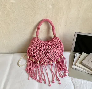 Detailansicht der rosa Macramé-Webtasche mit langen Fransen und Holzperlen-Verzierung