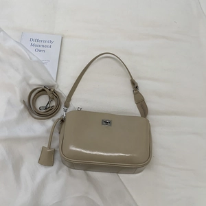 Detail of khaki faux leather baguette bag with silver twist lock and adjustable strap
