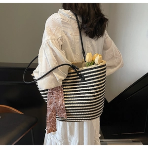 Détail du sac cabas en paille tissé à la main avec rayures noires et décor d'écharpe paisley