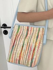 Colorful striped woven tote bag with light blue straps shown on model for casual daily use