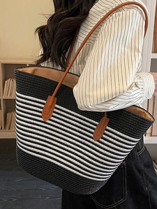 Large striped woven straw tote bag with brown leather handles for beach or casual travel