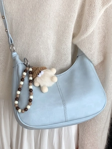 Sac bandoulière bleu clair en forme de croissant avec pendentif peluche et perles