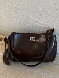 Deep brown patent leather baguette shoulder bag with silver square clasp and thin strap