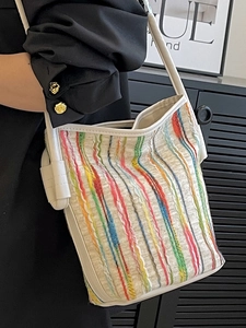 White canvas bucket bag with colorful vertical embroidery and white shoulder strap
