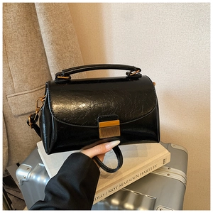 Vue détaillée du sac à main rétro noir avec fermoir doré sur une scène de voyage