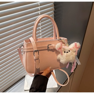 Pink faux leather crossbody bag with a cute white bunny pendant and top handle detail