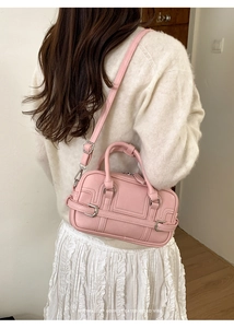 Détails du sac bowling rose avec bandoulière à boucle métallique et texture en cuir PU