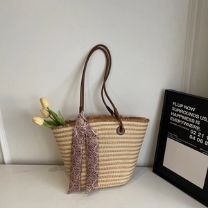 Detail of handmade straw woven tote with striped pattern and paisley scarf decoration