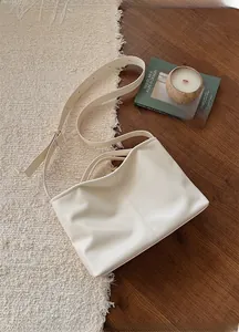 Detailed view of cream-colored PU leather tote bag with central stitching and handles