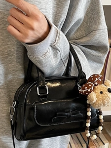 Chic black patent leather bow handbag with cute plush bear charm for spring 2026 fashion