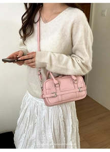 Détail du sac Boston en cuir rose avec boucle rétro et surpiqûres élégantes