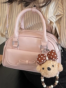 Pink glossy patent leather bow handbag with teddy bear charm and adjustable shoulder strap