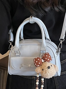 Minimalist light blue bow bowling bag with a cute plush bear pendant shown on model