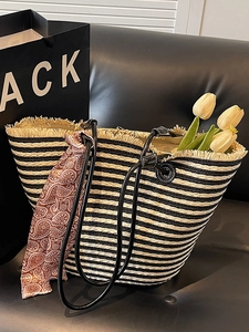 Handwoven straw tote bag with black and beige stripes, fringe trim and paisley scarf