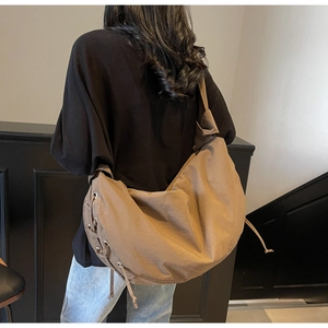 Vue arrière du sac besace kaki avec détails de cordons de serrage sur modèle