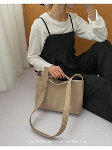 Close-up of the vintage-style beige tote bag with adjustable shoulder strap detail
