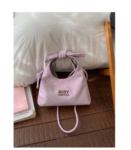 Detail of lavender suede handbag with knot handle and Rosy Doedian brand embroidery