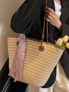 Handmade straw tote bag with brown leather handles and decorative silk scarf detail
