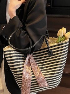 Handwoven straw tote bag with black and white stripes and a patterned silk scarf