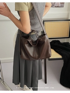 Detailed view of dark brown soft faux leather tote bag with wide shoulder strap design