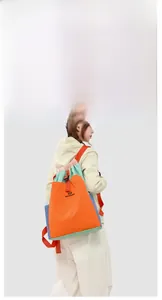 Detail of color-block drawstring backpack with orange webbing and NORTHKANSEN logo