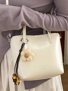 Minimalist beige leather bucket bag with quilted flower charm for women daily fashion