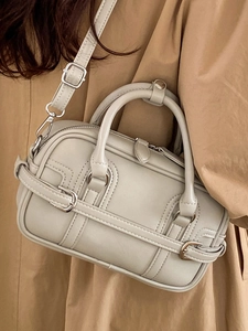 Sac bowling rétro chic gris clair style Boston porté avec un trench-coat élégant