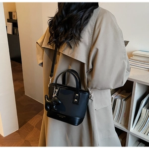 Détail du sac seau noir en PU avec breloque chien mignonne et poignées supérieures